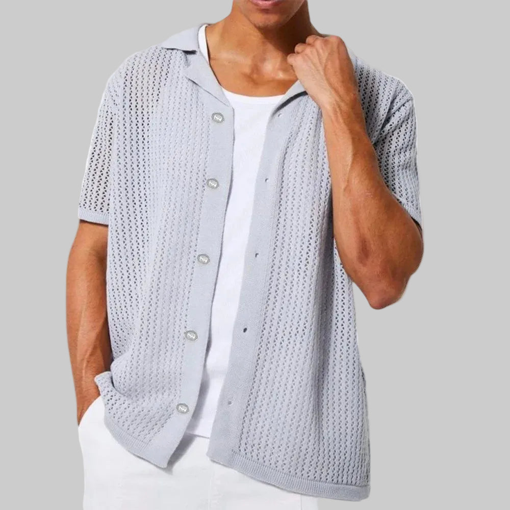 Man wearing a light gray textured cardigan over a white shirt on a white background