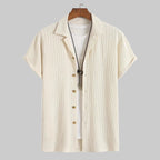Beige short-sleeve shirt with zipper on a hanger against a white background