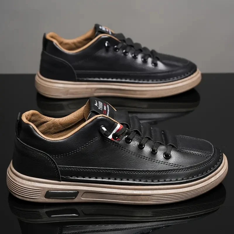 Black leather sneakers with tan accents on a reflective surface