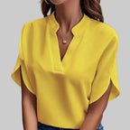 Person wearing a yellow blouse and blue jeans against a gray background
