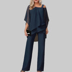 Woman wearing a navy blue outfit with a blurred indoor background