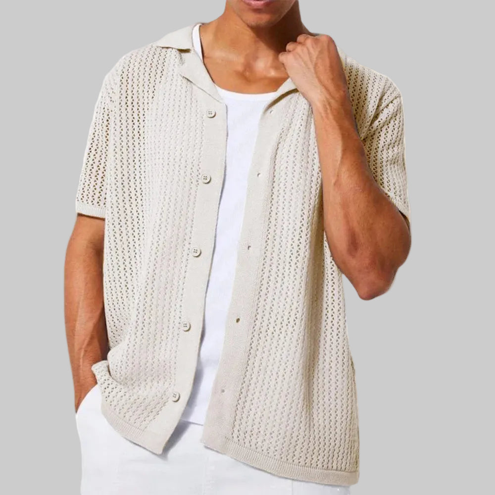 Man wearing a beige knitted vest over a white shirt on a white background