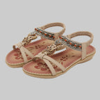 Beige sandals with decorative straps and floral patterns on a white background