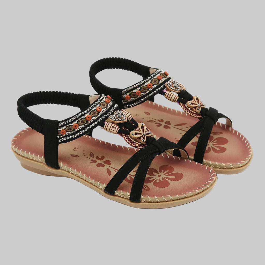 Black strappy sandals with floral design on a white background