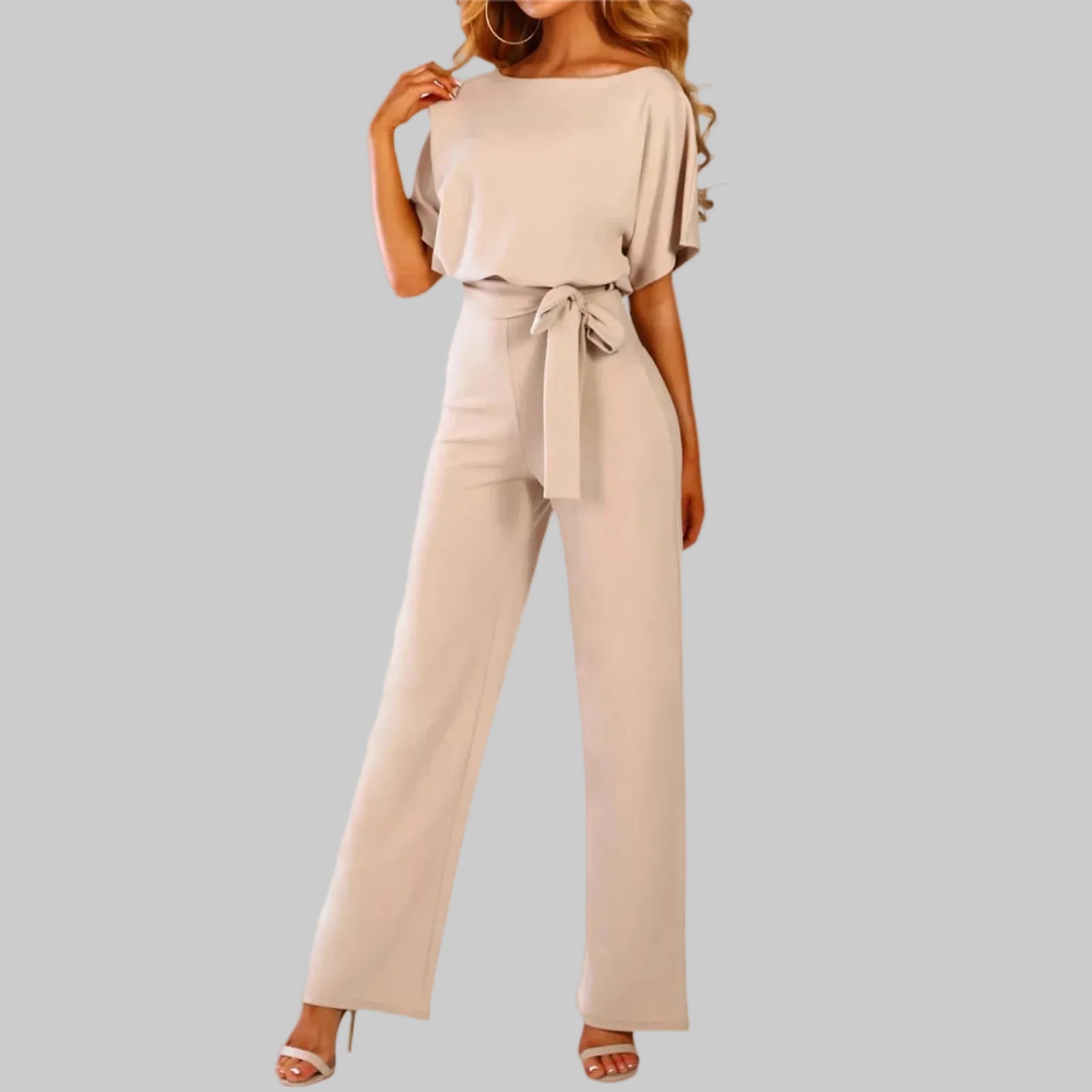 Beige jumpsuit worn by a model on a white background