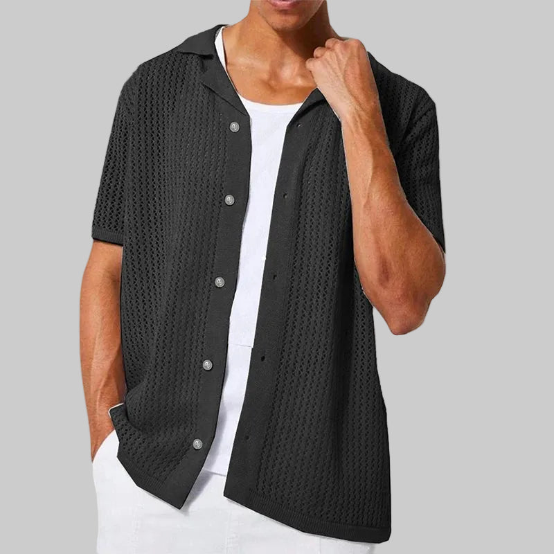 Person wearing a black textured cardigan over a white shirt on a white background