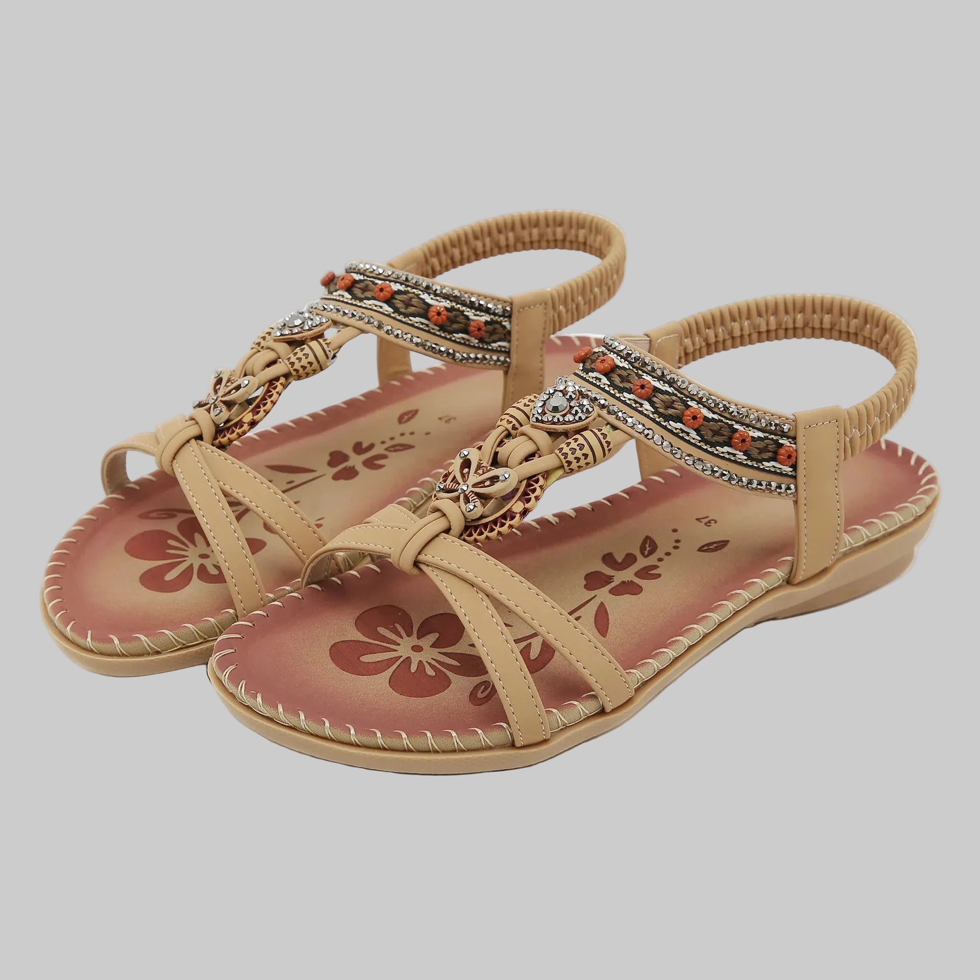 Beige sandals with floral patterns on a white background