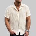 Man wearing a beige short-sleeve button-up shirt on a white background