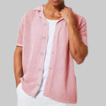 Person wearing a pink knitted cardigan over a white shirt on a white background