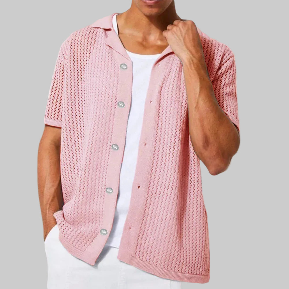Person wearing a pink knitted cardigan over a white shirt on a white background