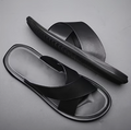 Black slide sandals on a gray background